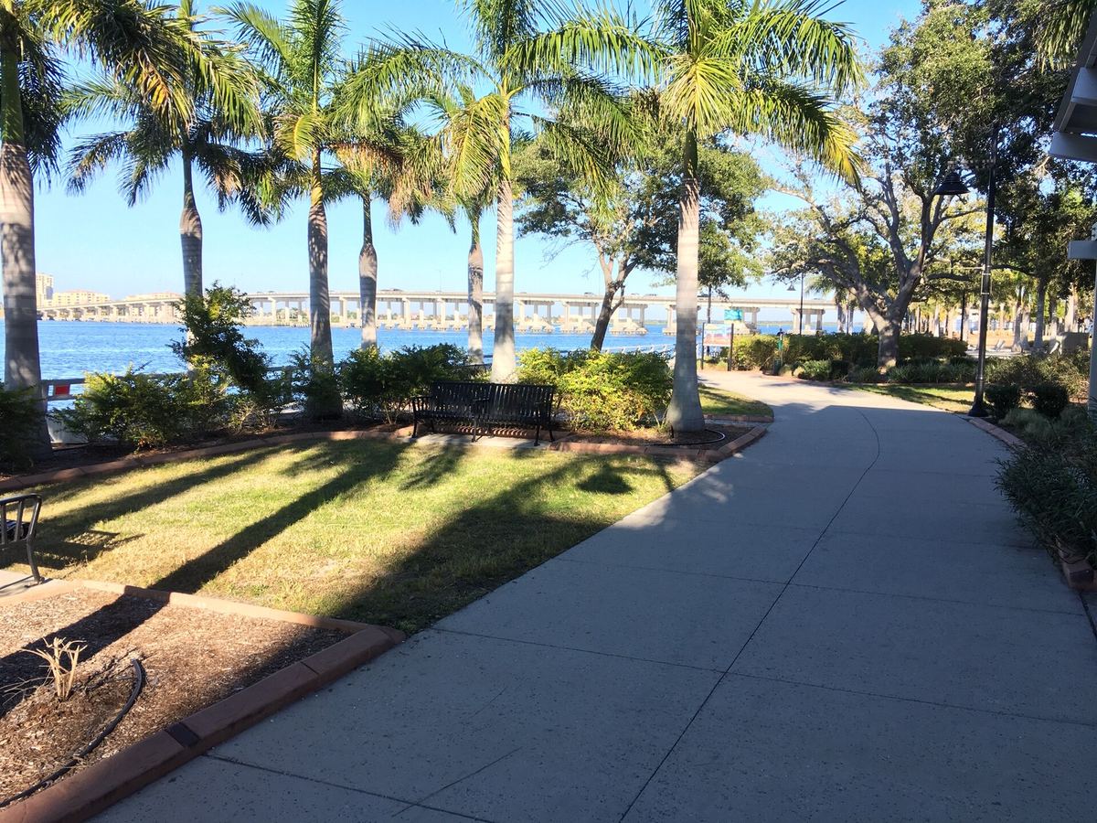 Palm-lined path on the Bradenton Riverwalk beside the Manatee River, a viewing spot for the holiday boat parade